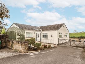 A house with a driveway and fence at White Gables in Great Clifton near Cockermouth