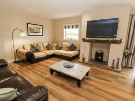 A living room with a TV and sofa at White Gables in Great Clifton near Cockermouth