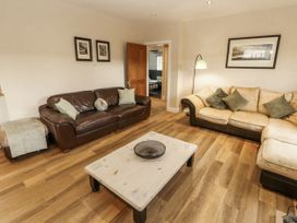 A living room with a brown sofa and coffee table at White Gables Great Clifton near Cockermouth