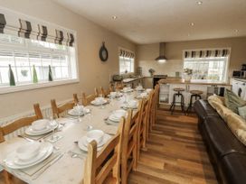 A dining room with a long table set for a meal at White Gables near Cockermouth