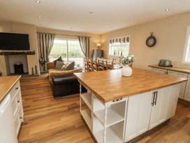 A kitchen with an island, sofa, and dining area at White Gables in Great Clifton near Cockermouth