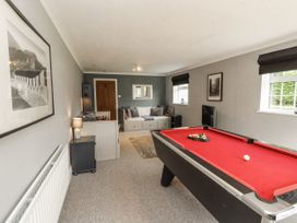 A snug with a pool table and a sofa at White Gables in Great Clifton near Cockermouth