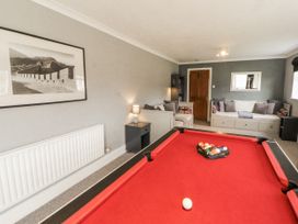 A snug with a pool table and sofa at White Gables in Great Clifton near Cockermouth