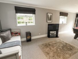 A living room with a sofa and a TV at White Gables in Great Clifton near Cockermouth