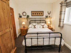 A bedroom with a bed and wooden furniture at White Gables in Great Clifton near Cockermouth