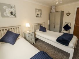 A bedroom with two single beds at White Gables in Great Clifton near Cockermouth