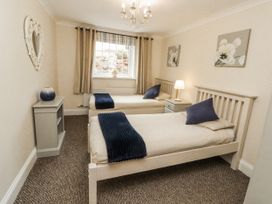 A bedroom with two beds and a window at White Gables in Great Clifton near Cockermouth