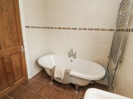 A bathroom with a bathtub and towel rack at White Gables in Great Clifton near Cockermouth