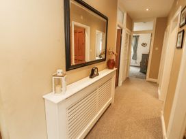 A hallway with a mirror and a clock at White Gables in Great Clifton near Cockermouth