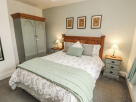 A bedroom with a bed and wardrobe at White Gables Great Clifton near Cockermouth