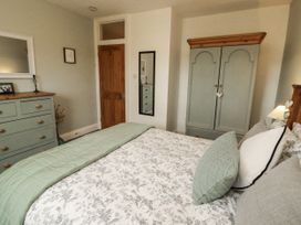 A bedroom with a bed and drawers at White Gables in Great Clifton near Cockermouth
