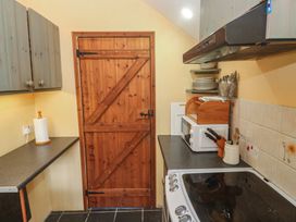A kitchen with wooden door and appliances at Longhouse St Keverne, Lizard Peninsula