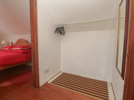 A bedroom with a bed and a closet at Longhouse St Keverne, Lizard Peninsula