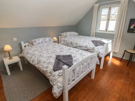 A bedroom with two beds and a window at Longhouse in St Keverne, Lizard Peninsula
