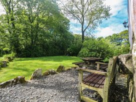 A garden with a bench and table at Longhouse, St Keverne, Lizard Peninsula