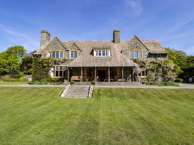 Stone house with two chimneys and a large lawn in front at Plas Gwynfryn in Llanbedr