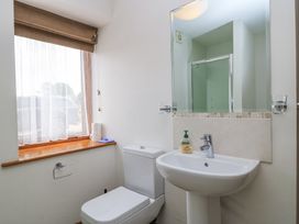 A bathroom with a toilet sink mirror window and shower at Shepherd's Barn Between Milborne St Andrew and Winterborne Whitechurch