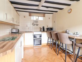 A kitchen with a wooden countertop stove and oven and high chairs at Y Bwthyn in Llanbedr near Harlech