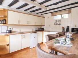 A kitchen with beige cabinets wooden countertops a small fridge toaster and kettle at Y Bwthyn Llanbedr near Harlech