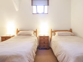 A bedroom with two single beds and two bedside tables with lamps at Y Bwthyn in Llanbedr near Harlech
