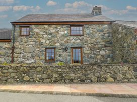 A stone cottage with windows and a door at Daffodil Cottage Caeathro near Caernarfon