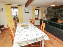 A dining room with a table and chairs at Daffodil Cottage Caeathro near Caernarfon