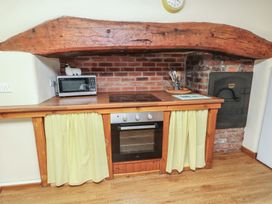 A kitchen with a wooden countertop and oven at Daffodil Cottage Caeathro near Caernarfon