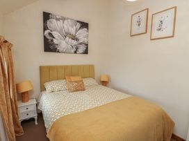 A bedroom with a bed and lamps at Daffodil Cottage in Caeathro near Caernarfon