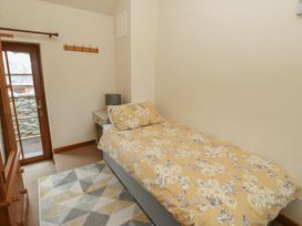 A bedroom with a bed and bedside table at Daffodil Cottage Caeathro near Caernarfon