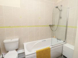 A bathroom with a bathtub and toilet at Daffodil Cottage in Caeathro near Caernarfon