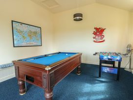 A game room with pool and foosball tables at Daffodil Cottage Caeathro near Caernarfon