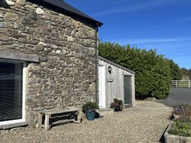 An outdoor area with a stone wall and a bench at Y Cwtch Newport