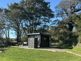 A shed in a garden with trees and grass at Y Cwtch Newport