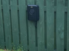 A charging station mounted on a green wooden fence at Cra-na-ge in Embleton