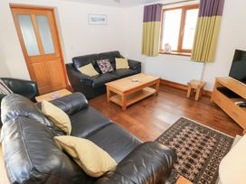 A living room with a sofa and coffee table at Bwthyn Trecoed St. Clears near Carmarthen