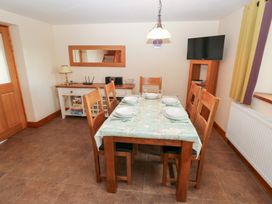 A dining room with a table and chairs at Bwthyn Trecoed in St. Clears near Carmarthen