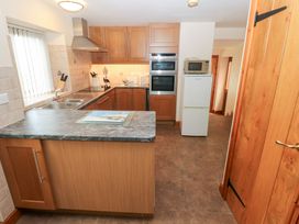 A kitchen with cabinets, a sink, and appliances at Bwthyn Trecoed in St. Clears near Carmarthen