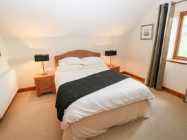 A bedroom with a bed and nightstand at Bwthyn Trecoed St. Clears near Carmarthen