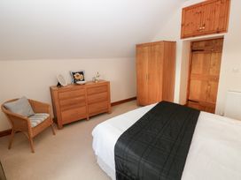 A bedroom with furniture including a bed, dresser, and wardrobe at Bwthyn Trecoed St. Clears near Carmarthen