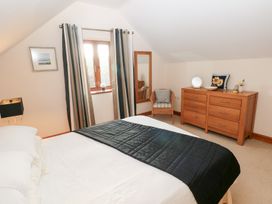 A bedroom with a bed and dresser at Bwthyn Trecoed in St. Clears near Carmarthen