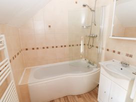 A bathroom with a bathtub, shower, and sink at Bwthyn Trecoed in St. Clears near Carmarthen