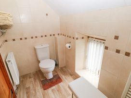 A bathroom with a toilet and towels on a shelf at Bwthyn Trecoed St. Clears near Carmarthen