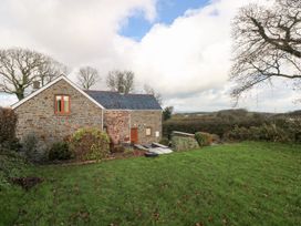 A stone house with green grass and trees at Bwthyn Trecoed St. Clears near Carmarthen