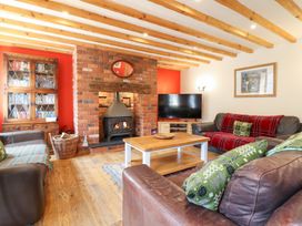 A living room with a fireplace, television, and furniture at Ysgubor Pwlliago in Pennant Valley near Llangynog