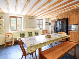 A kitchen with a table, chairs, and appliances at Ysgubor Pwlliago in Pennant Valley near Llangynog