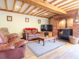A living room with a sofa and a wood stove at Ysgubor Pwlliago Pennant Valley near Llangynog