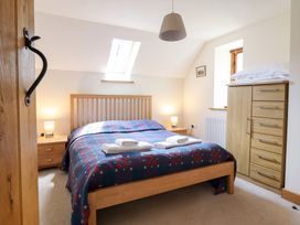 A bedroom with a bed and wardrobe at Ysgubor Pwlliago Pennant Valley near Llangynog