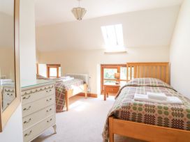 A bedroom with two single beds and a mirror at Ysgubor Pwlliago in Pennant Valley near Llangynog