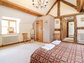 A bedroom with a bed, chairs, and a mirror at Ysgubor Pwlliago in Pennant Valley near Llangynog