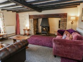 A living room with a fireplace and furniture at Penlone Cottage in Rhayader